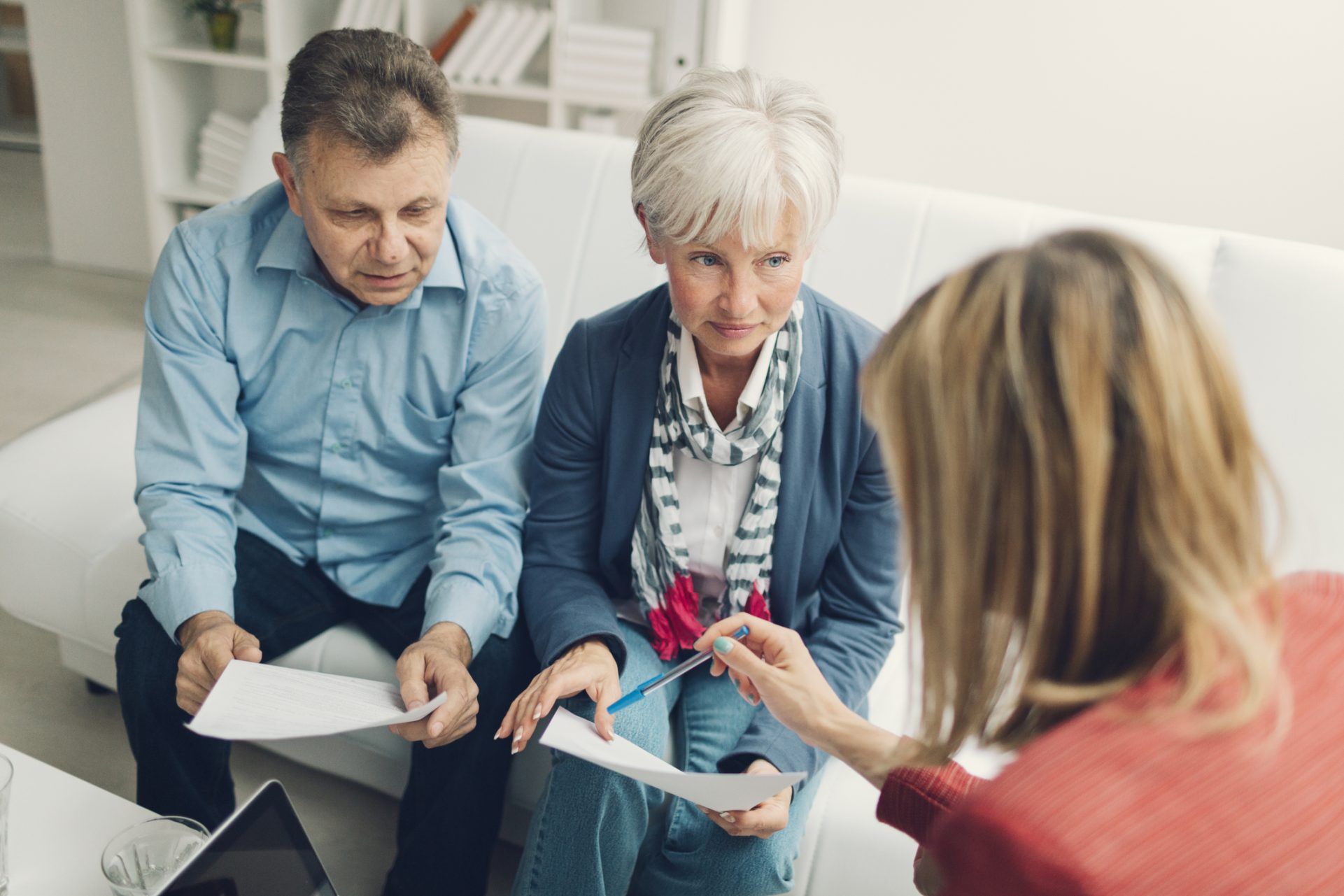 Olivia Wann Law Office, Elder Law.  Mature Couple Meeting with Financial Advisor, who is pointing with pencil to some contract details.