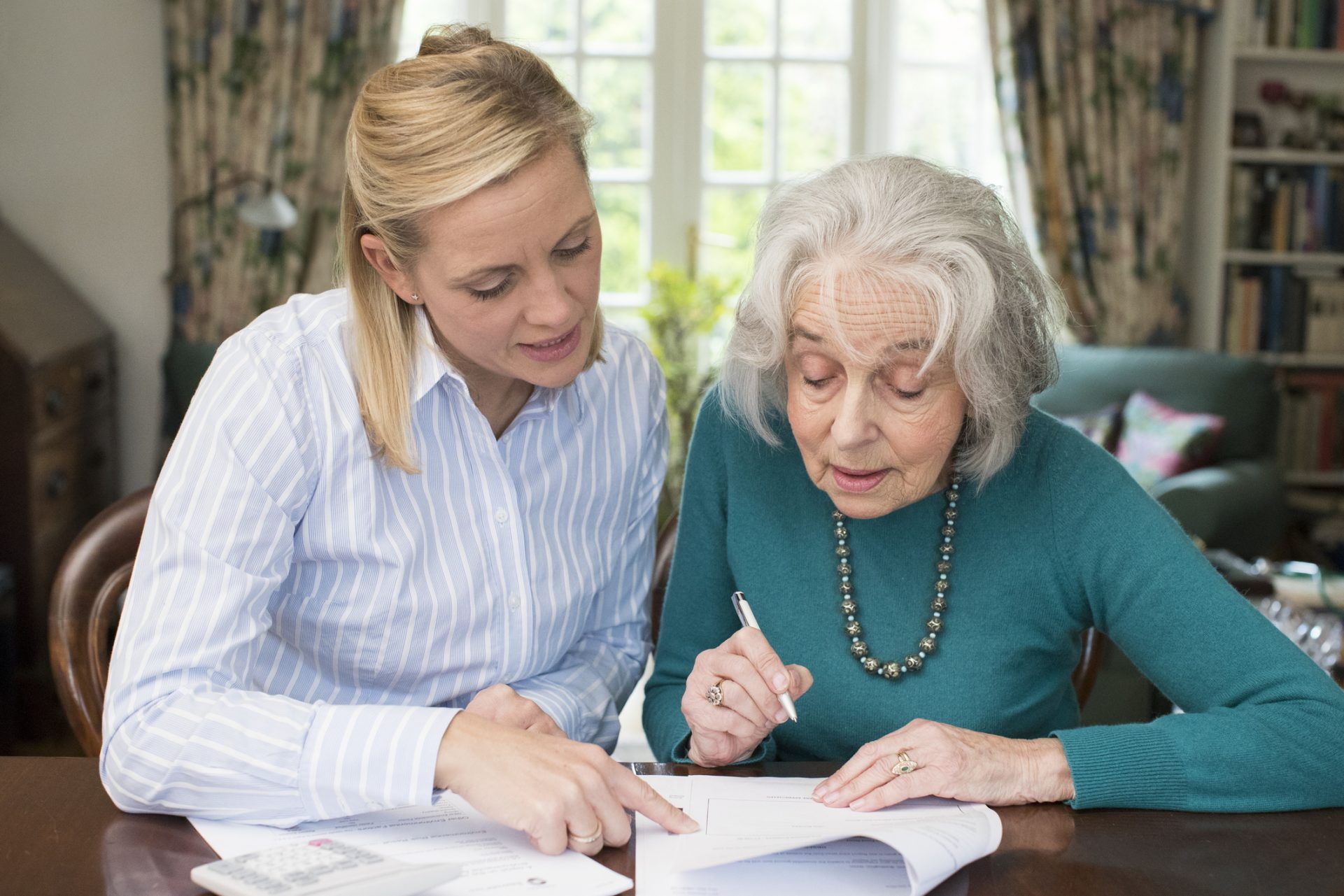 Woman Helping Senior Adult Neighbor With Paperwork, Estate planning & elder law